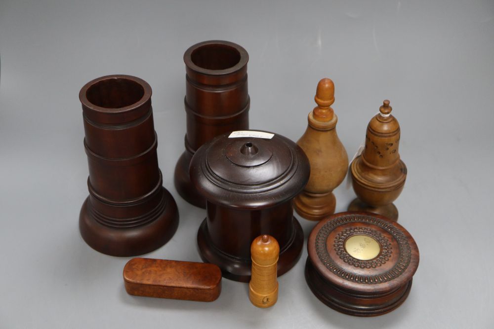 Eight items of treen including a pair of spill vases, height 16cm, a string box and a caster,